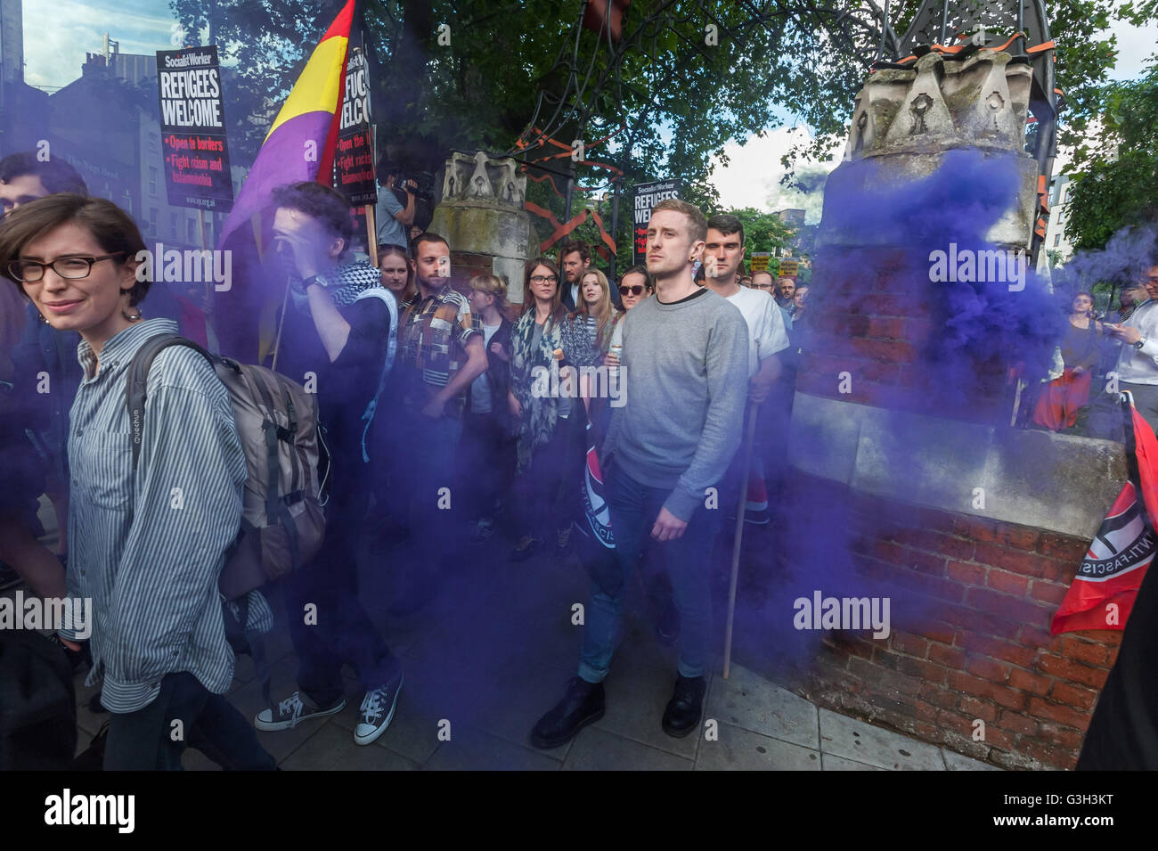 London, UK. June 24th 2016. Over a thousand protesters leave Altab Ali Park through the smoke form a flare on a long march to the offices of News International on the day after the UK voted to leave the EU. They were protesting against racism, for migrant rights and against fascist violence and argue that migration and immigrants have been attacked and scapegoated not only by both Remain and Leave campaigns but by mainstream parties and media over more than 20 years, stoking up hatred by insisting immigrants are a 'problem'. Peter Marshall/Alamy Live News Stock Photo