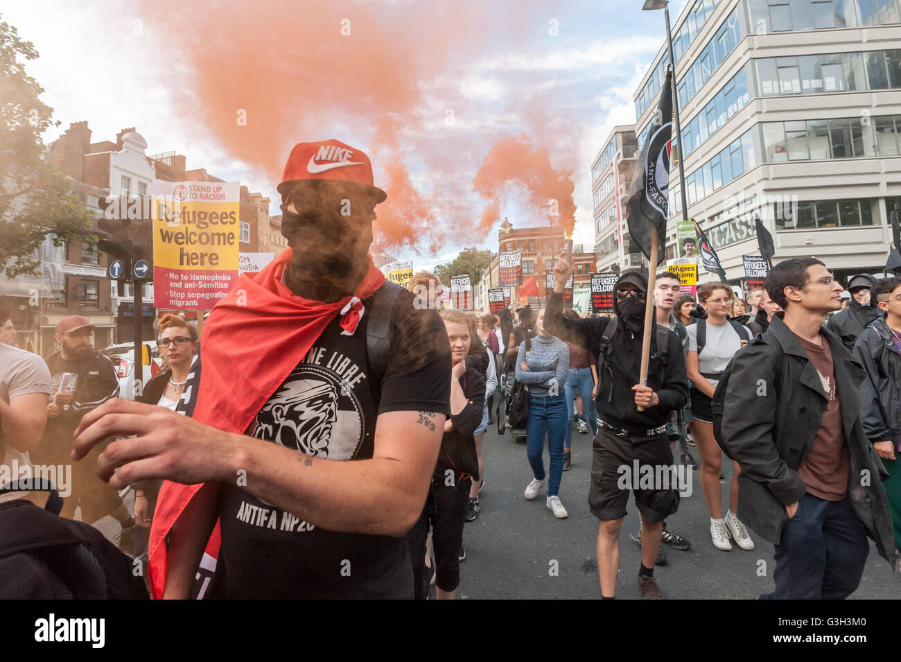 London, UK. June 24th 2016. Flares are set off on the long march from Altab Ali Park to the offices of News International on the day after the UK voted to leave the EU. They were protesting against racism, for migrant rights and against fascist violence and argue that migration and immigrants have been attacked and scapegoated not only by both Remain and Leave campaigns but by mainstream parties and media over more than 20 years, stoking up hatred by insisting immigrants are a 'problem'. Peter Marshall/Alamy Live News Stock Photo
