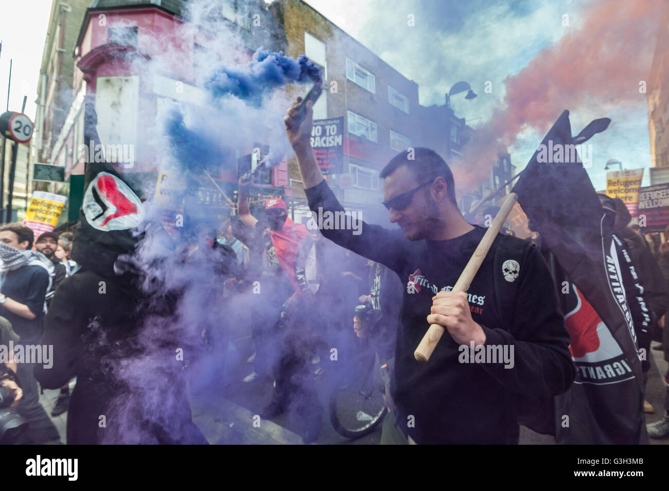 London, UK. June 24th 2016. Flares are set off on the long march from Altab Ali Park to the offices of News International on the day after the UK voted to leave the EU. They were protesting against racism, for migrant rights and against fascist violence and argue that migration and immigrants have been attacked and scapegoated not only by both Remain and Leave campaigns but by mainstream parties and media over more than 20 years, stoking up hatred by insisting immigrants are a 'problem'. Peter Marshall/Alamy Live News Stock Photo