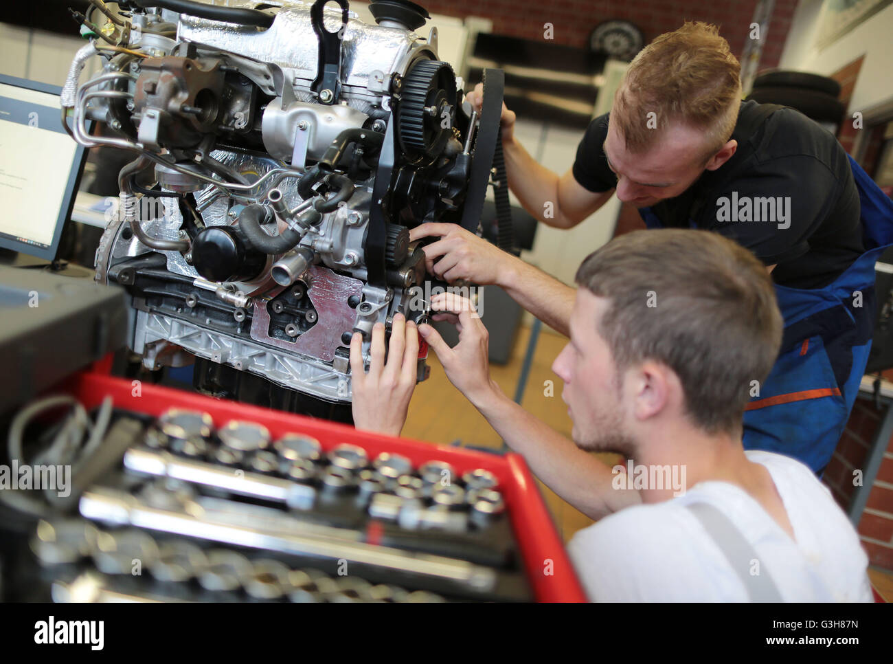 Automotive mechatronics engineer trainees work on a car at the training centre Butzweilerhof in Cologne, germany, 21 June 2016. Photo: Oliver Berg/dpa Stock Photo