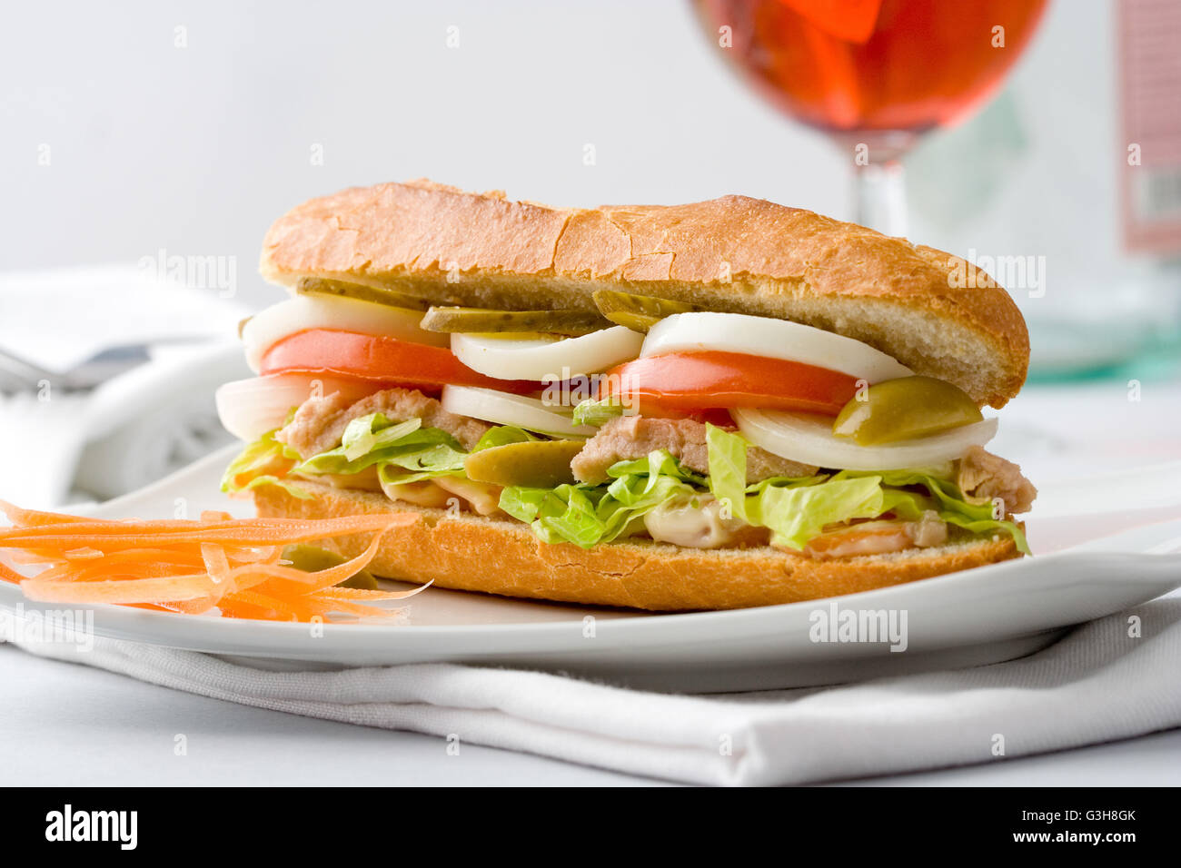 Healthy baguette sandwich with egg, tuna, tomato, pickles and lettuce