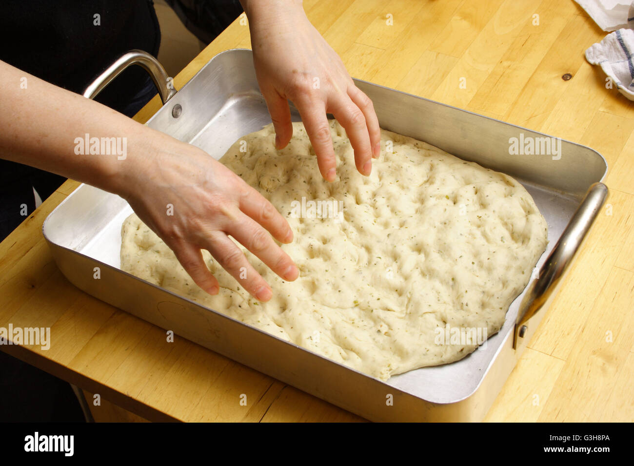 Woman in kitchen making focaccia dough Stock Photo