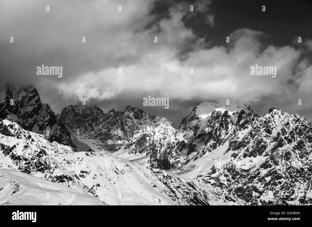 Black and white snowy rocks in clouds. Caucasus Mountains. Svaneti region of Georgia. Stock Photo