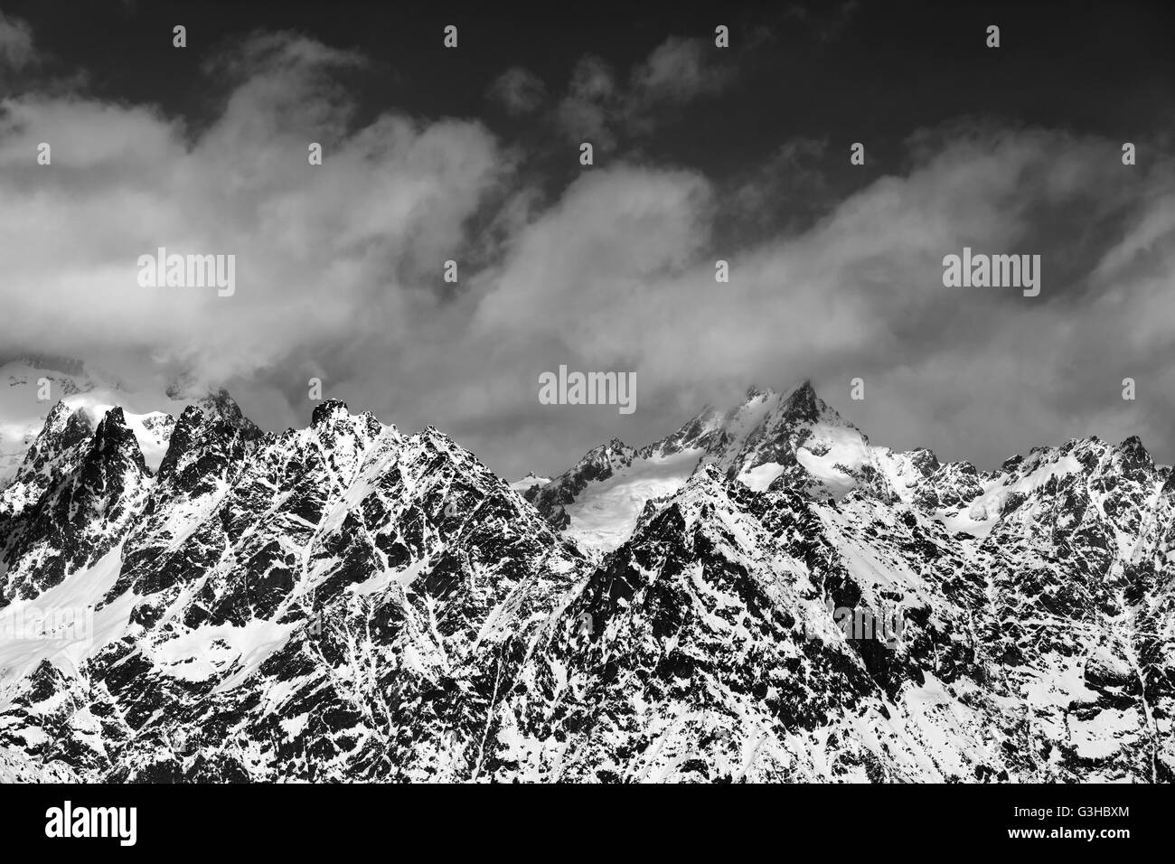 Black and white snowy rocks at sunny day. Caucasus Mountains. Georgia, region Svaneti. Stock Photo