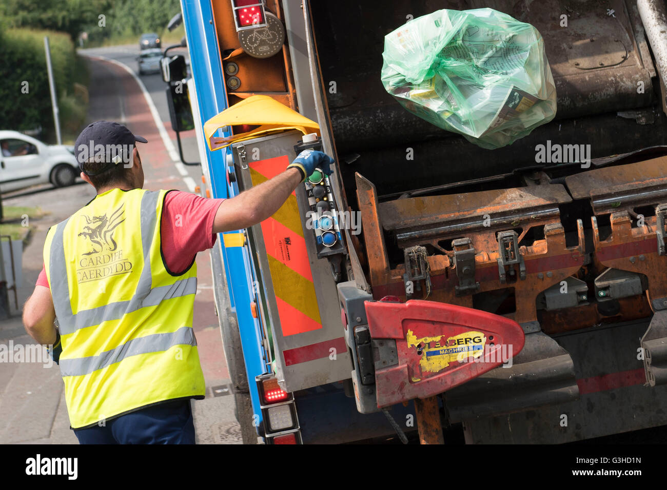 cardiff council worker throwing recycling bag into a bin garbage lorry Stock Photo