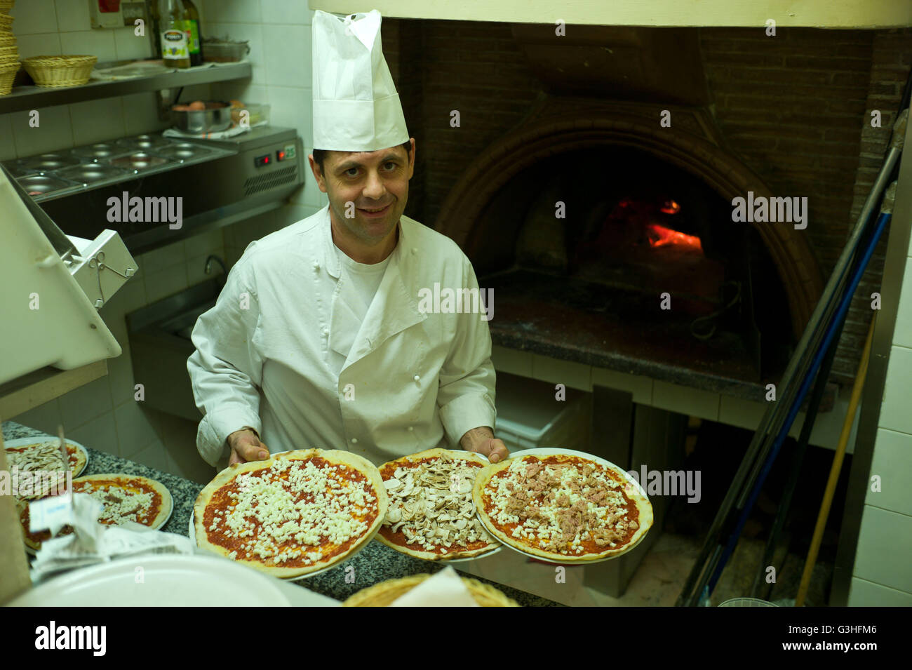 Chef preparing pizzas in a Restaurant  before cooking in a traditional pizza oven, Rome, Italy Stock Photo