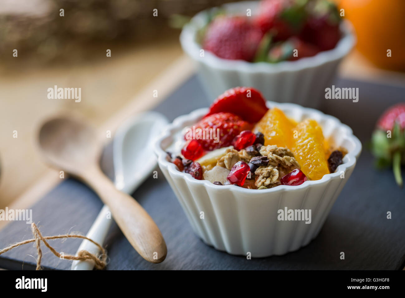 Granola with Orange, Strawberry, Cacao nibs and Pomegranate on yogurt Stock Photo