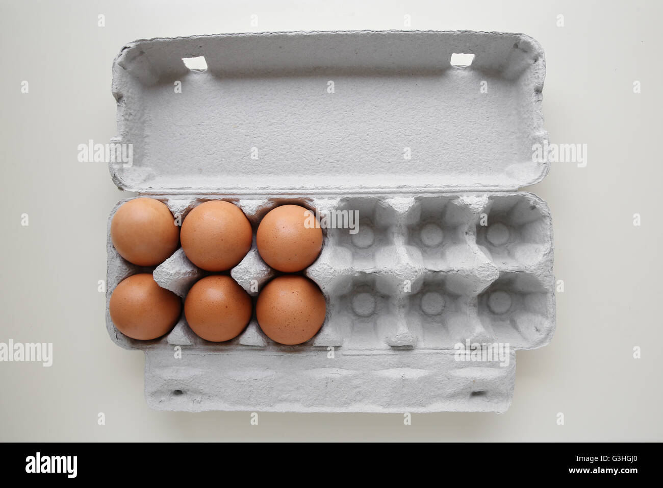 Eggs in packaging, missing eggs, half empty half full Stock Photo
