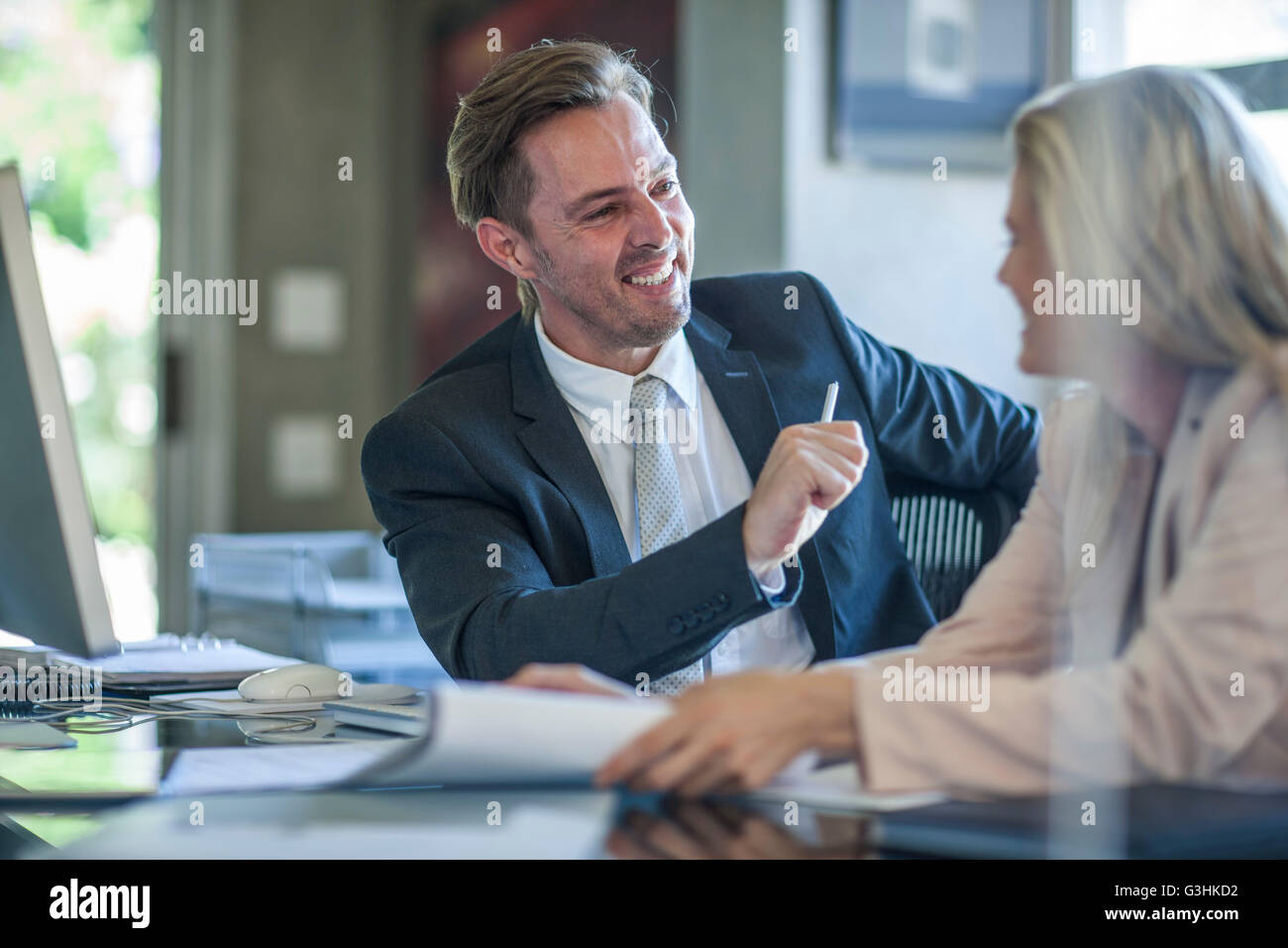 Businessman and woman meeting at office desk Stock Photo - Alamy