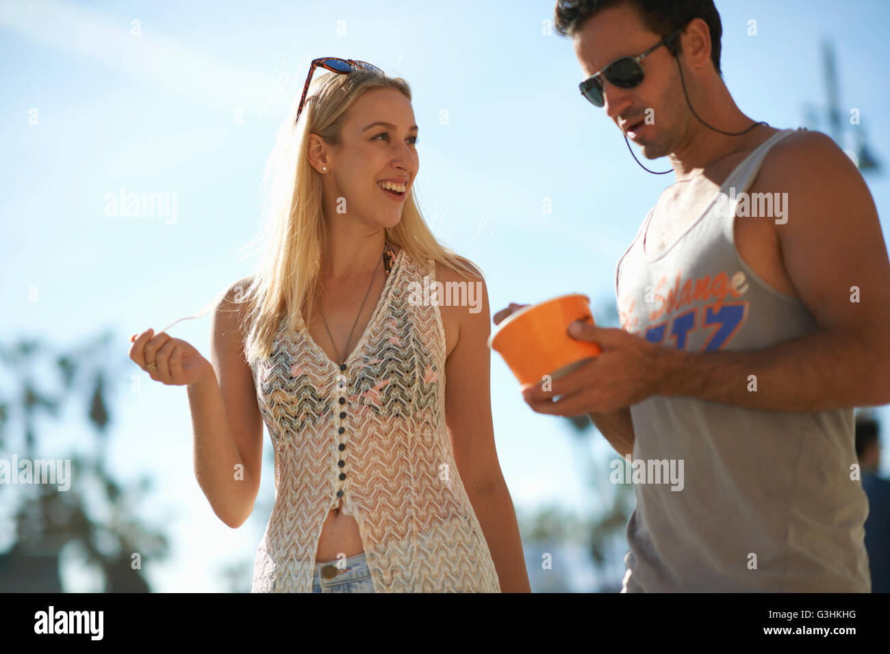 Couple strolling and eating frozen yoghurt at Venice Beach, California