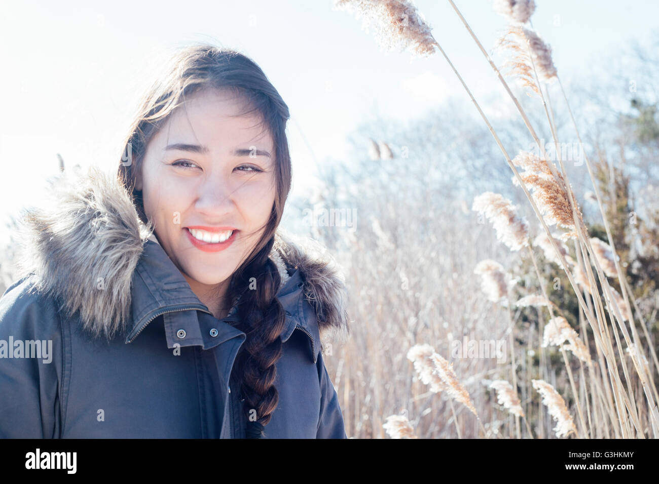 Portrait of woman wearing fur trimmed winter coat looking away smiling Stock Photo