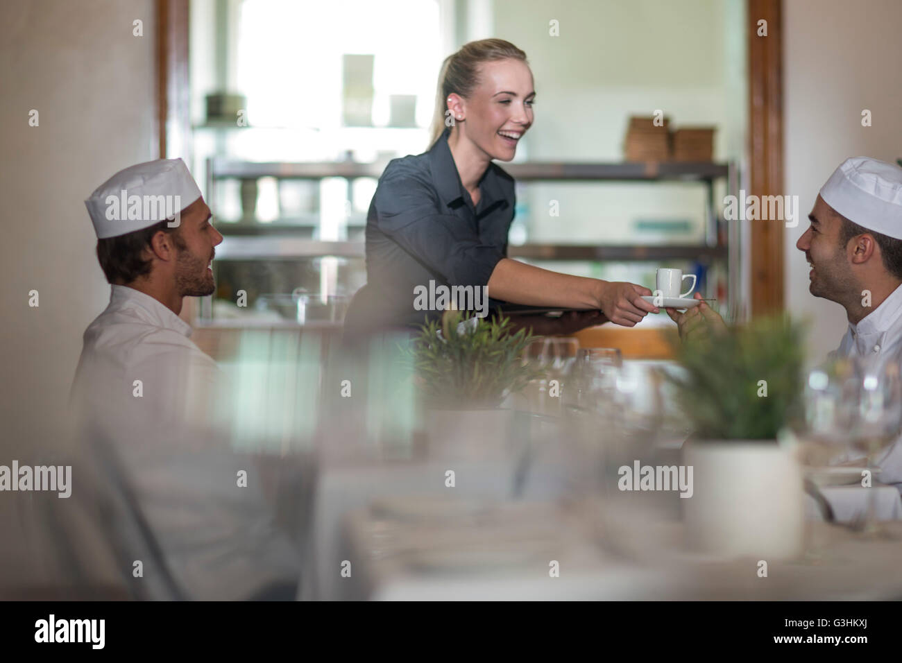 Waitress serving coffee to chefs at break time Stock Photo