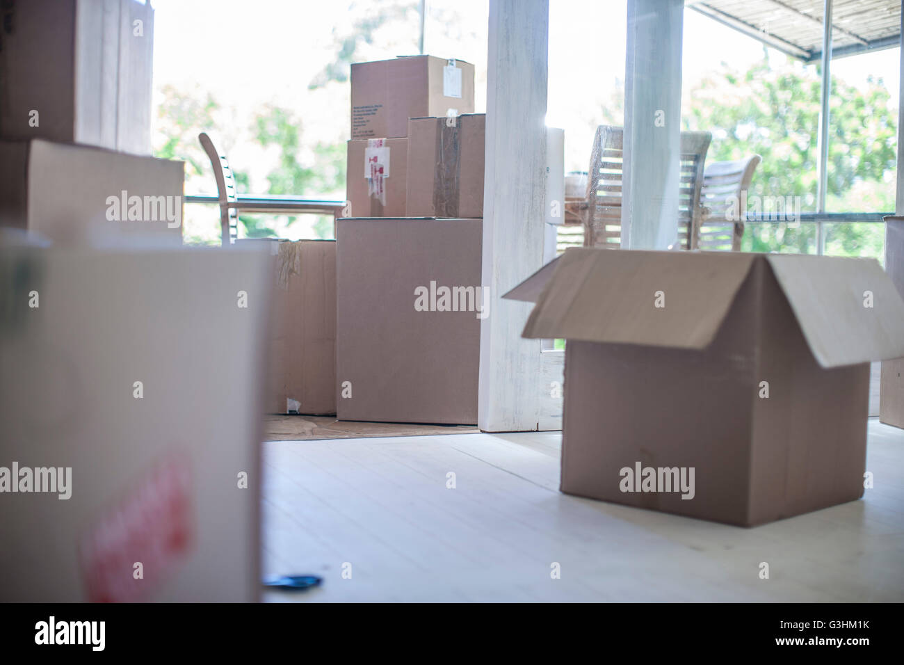 Moving house: Room filled with cardboard boxes Stock Photo