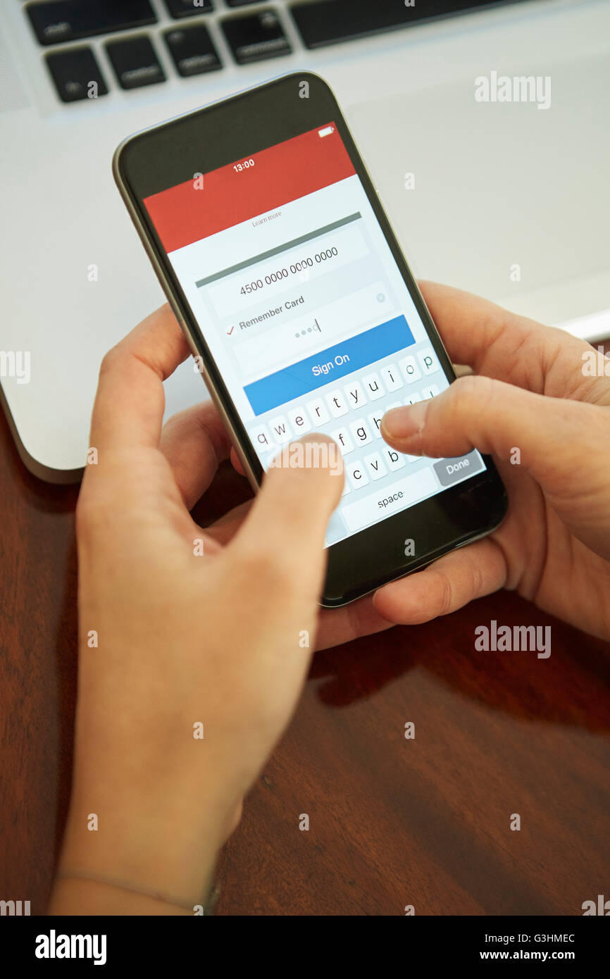 Womans hands holding smartphone signing on to internet banking Stock Photo
