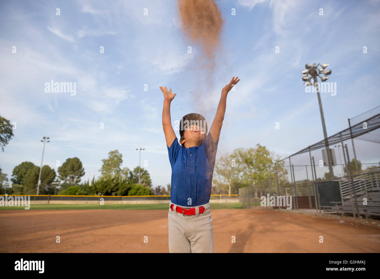 Boy throwing baseball glove mid air at baseball practise Stock Photo