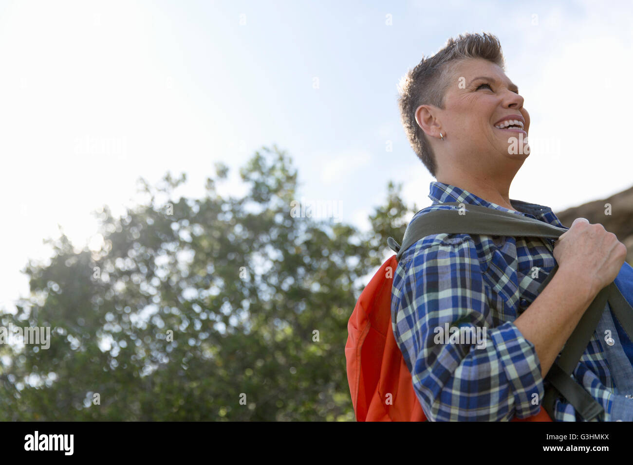 Woman carrying backpack looking away smiling Stock Photo