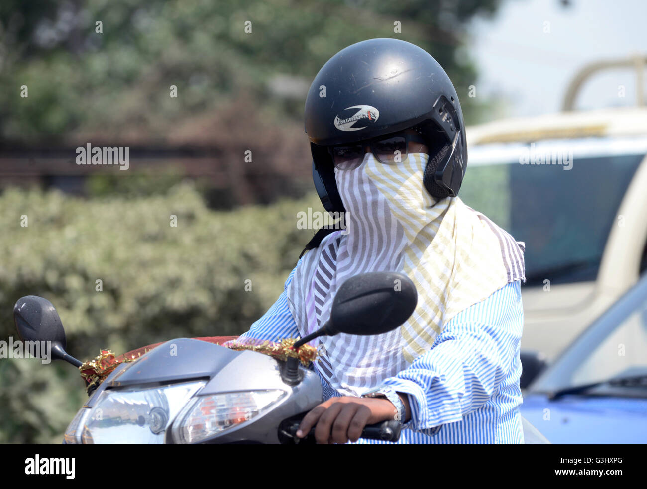 Biker cover his face with long clothes or towel due to this heat