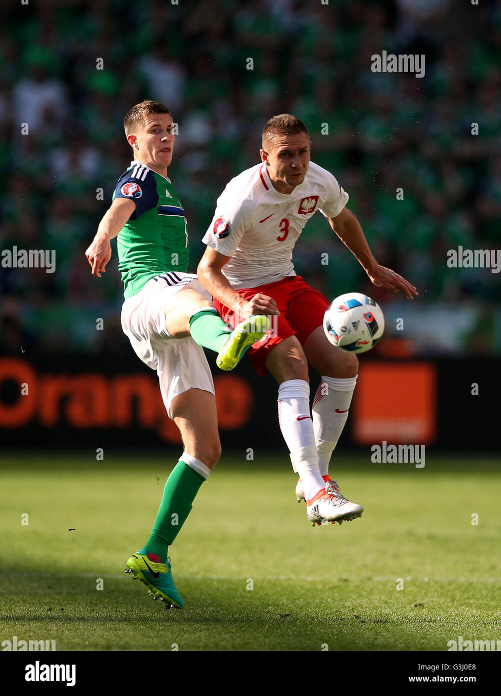 Northern Ireland's Paddy McNair (left) and Poland's Artur Jedrzejczyk battle for the ball during the UEFA Euro 2016, Group C match at the Stade de Nice, Nice. Stock Photo