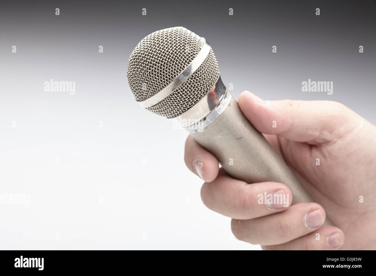 Microphone in a man's hand Stock Photo - Alamy