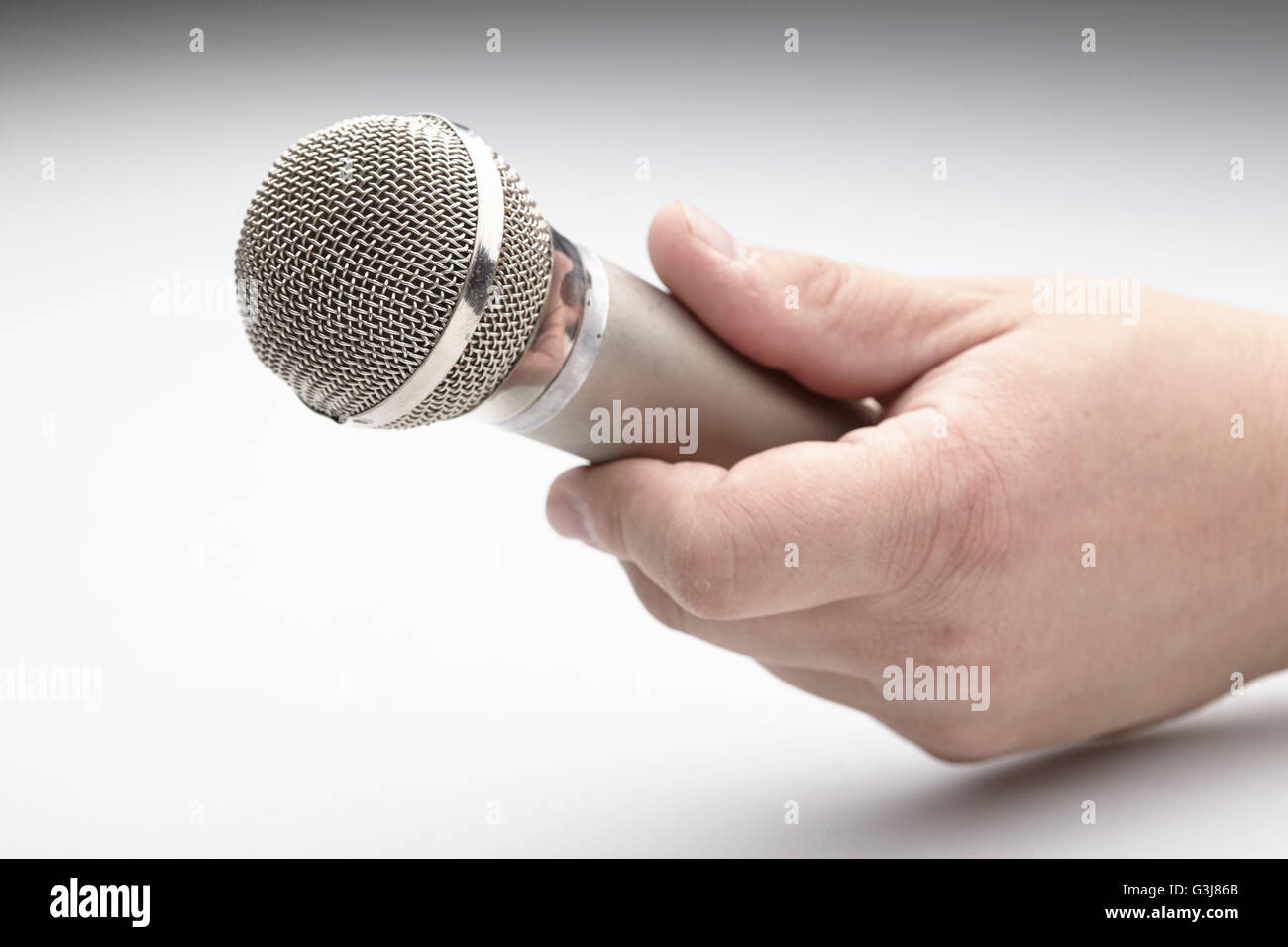 Microphone in a man's hand Stock Photo - Alamy