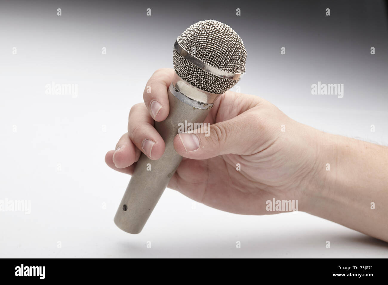 Microphone in a man's hand Stock Photo - Alamy