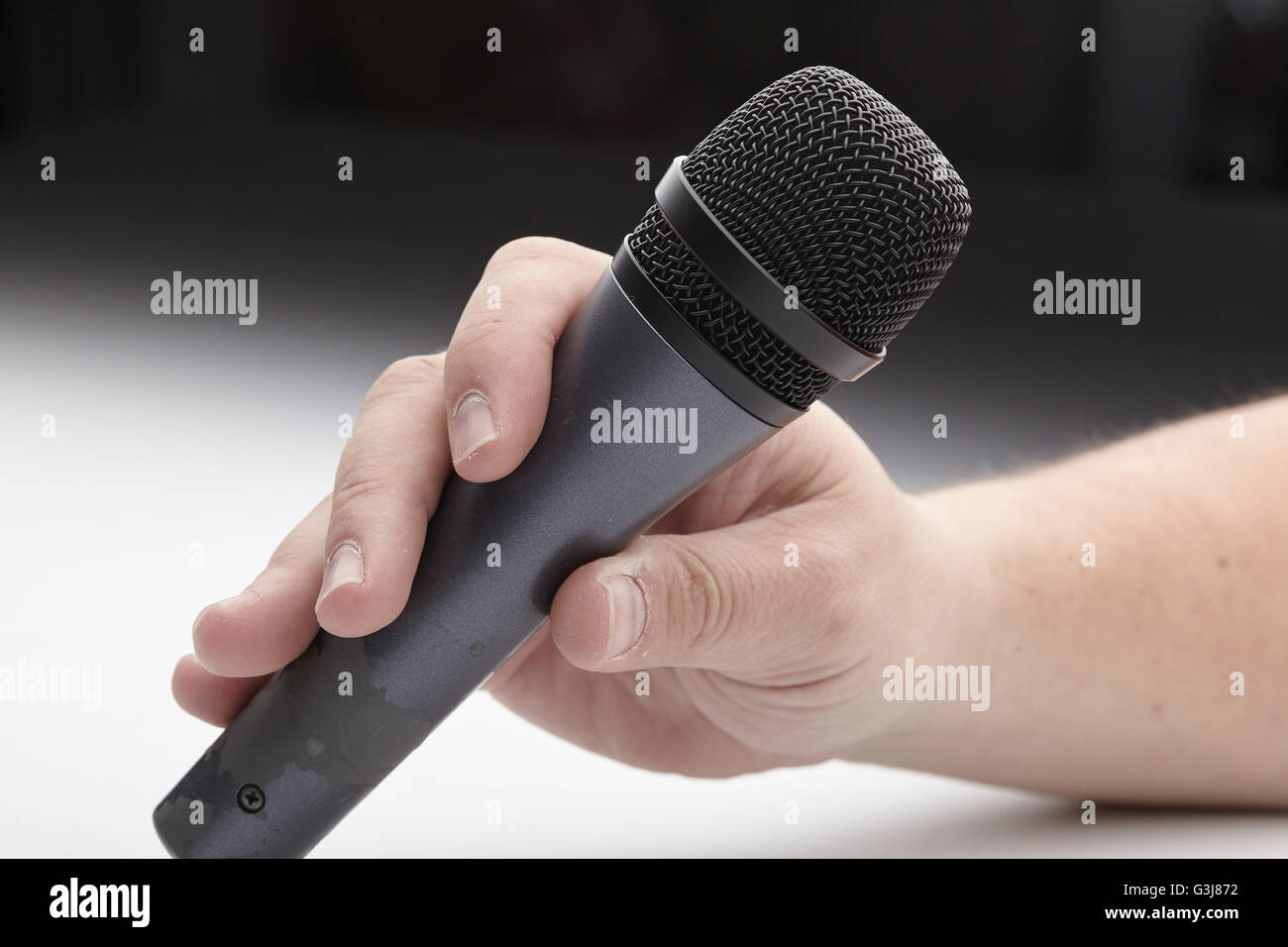 Microphone in a man's hand Stock Photo - Alamy