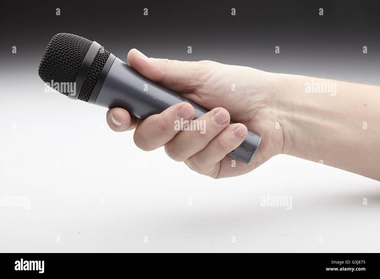 Microphone in a man's hand Stock Photo - Alamy