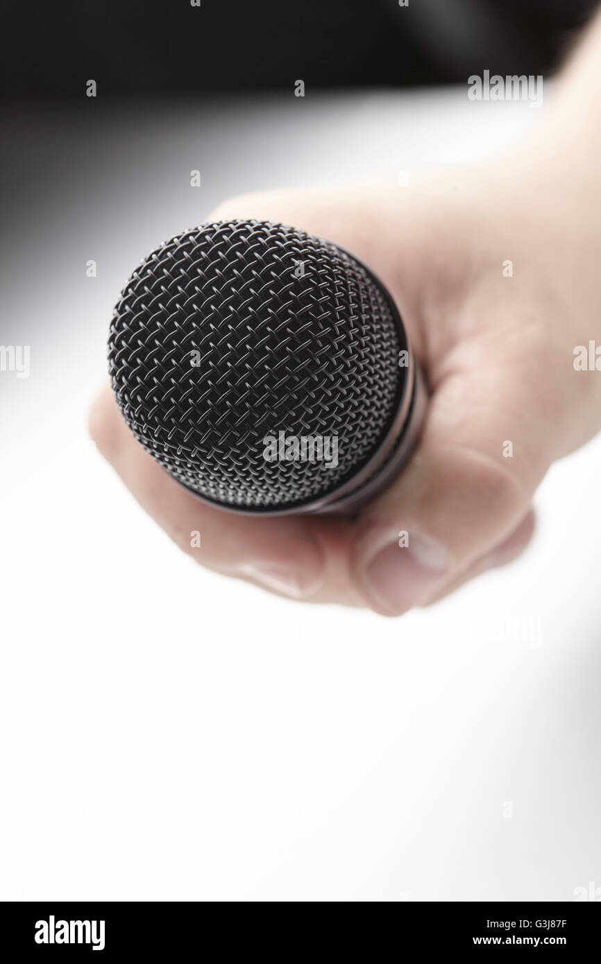 Microphone in a man's hand Stock Photo - Alamy