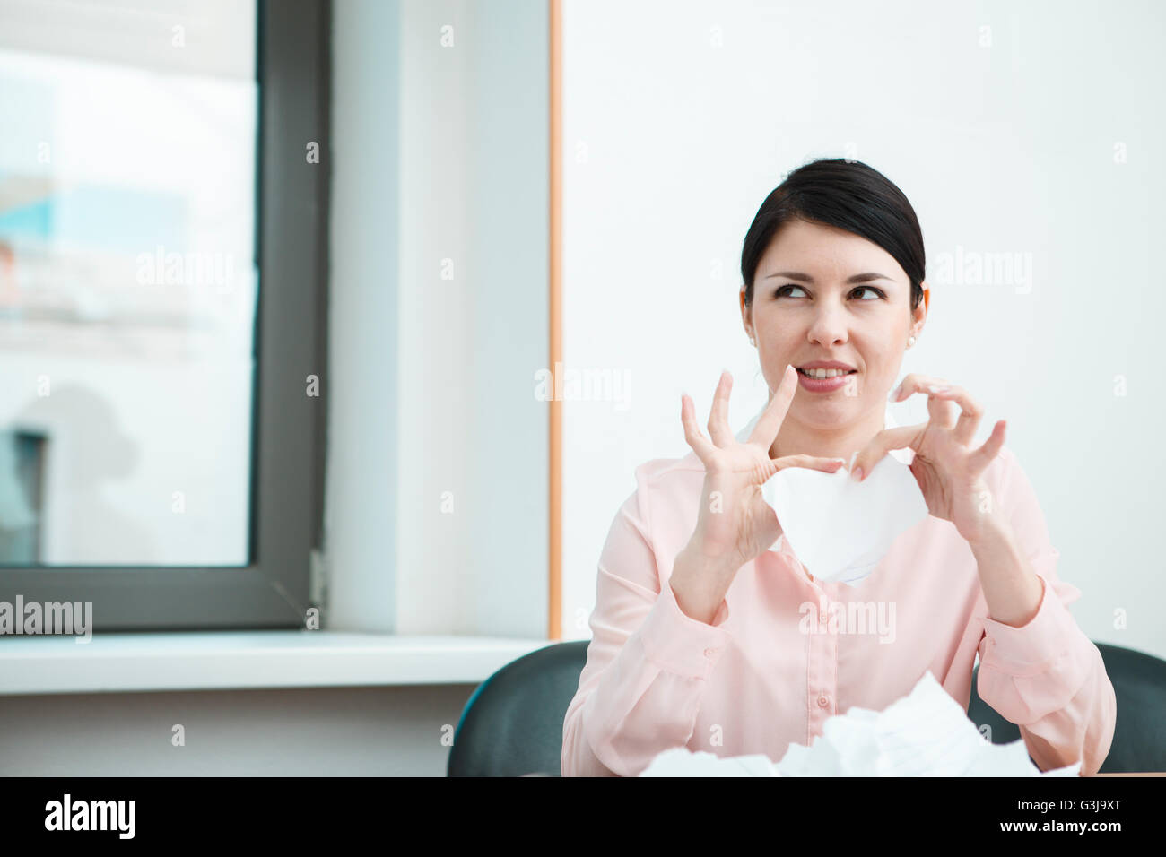 business woman sitting her desk getting rid of old papers with pleasure Stock Photo Alamy