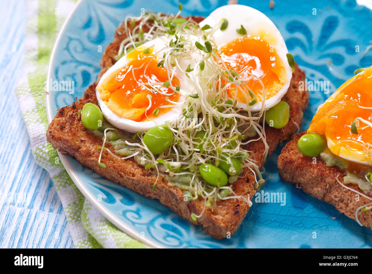 Avocado and egg whole wheat toast with edamame Stock Photo Alamy