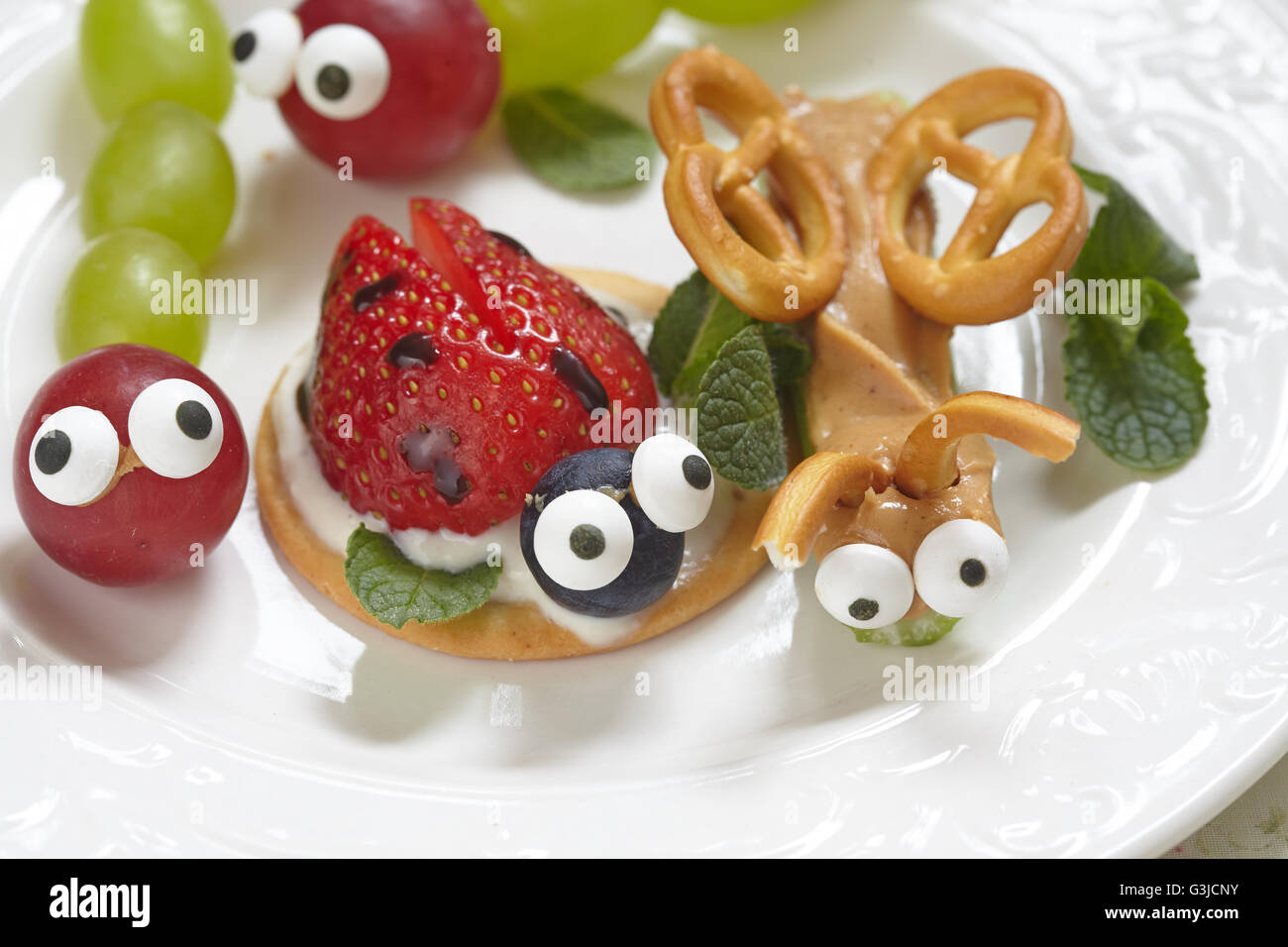 Funny beetles from grapes, berries and pretzels Stock Photo