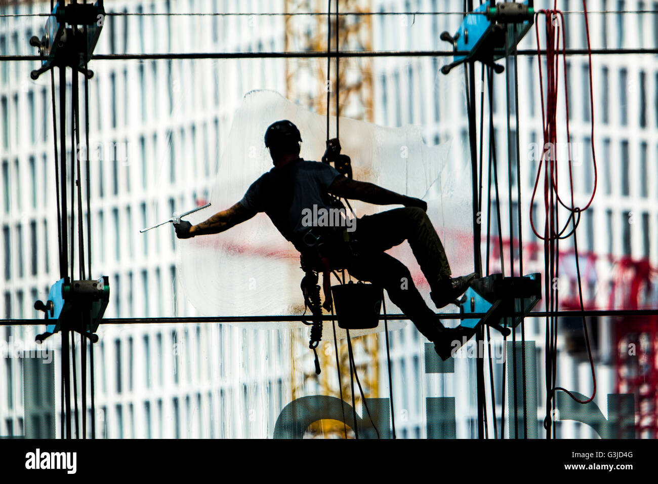 Window Cleaner Ropes Window cleaner, hanging on rope, cleans a large glass facade ...