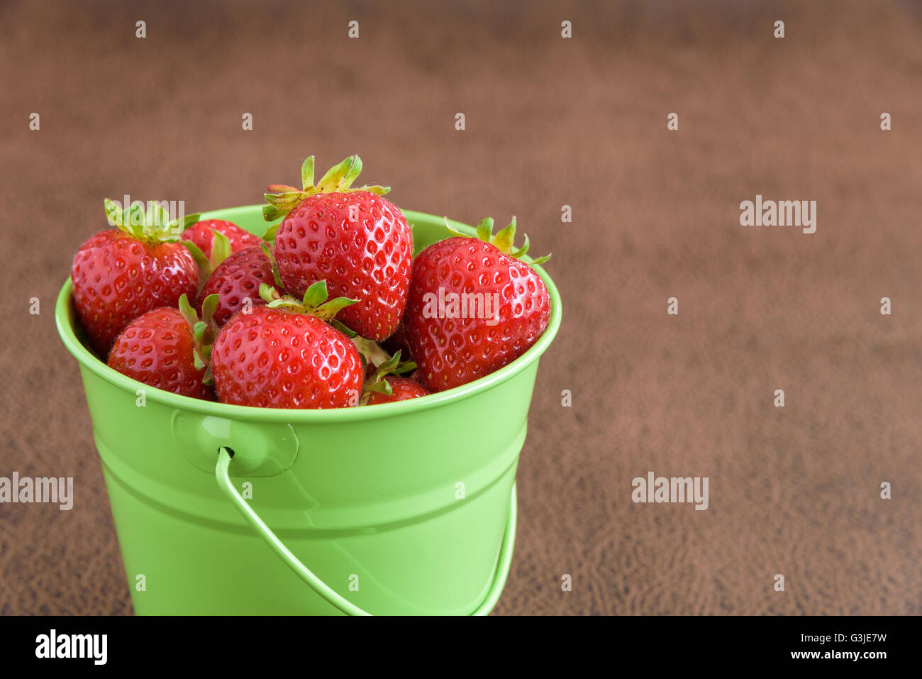 Strawberries with stems in a green bucket Stock Photo - Alamy