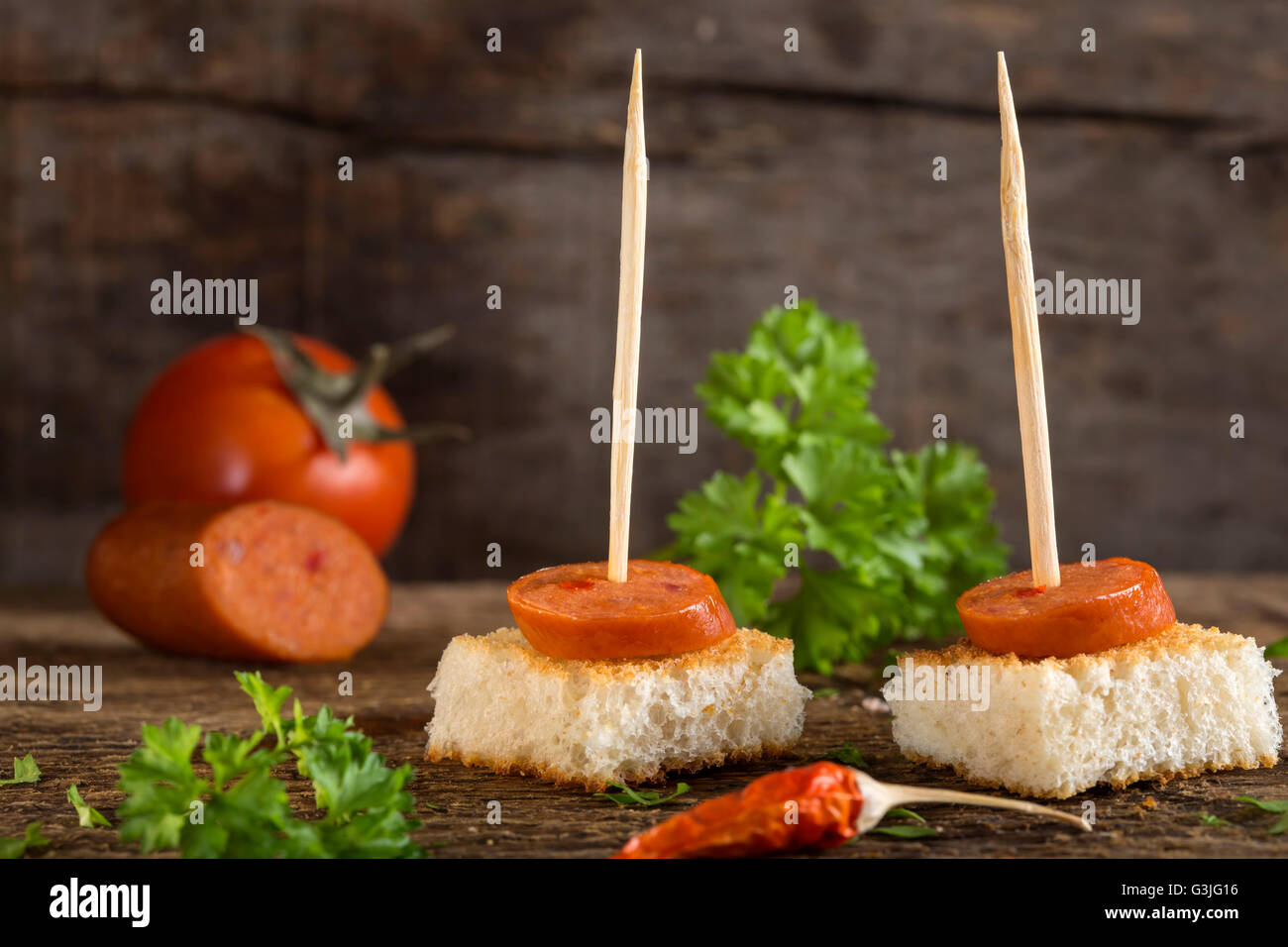 Appetizer made with paprika frankfurter sausage with herbs on wooden background Stock Photo