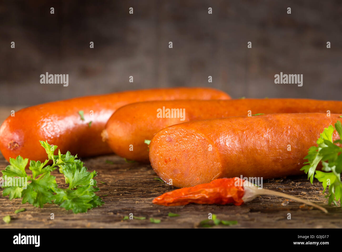 Paprika frankfurter sausage with herbs on wooden background Stock Photo