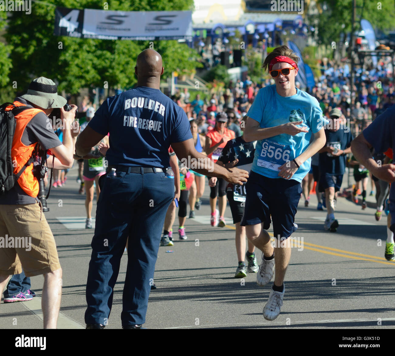 Boulder firefighter offers water to participant in the 2016 Bolder Boulder 10K. More than 50,000 participate each year. Stock Photo