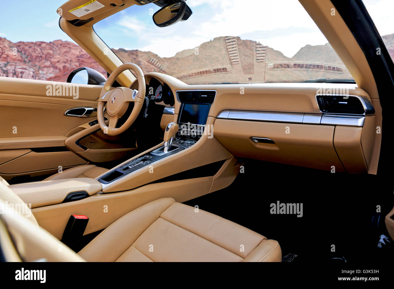 Interior dashboard dash console view of a Porsche 911 Carrera S on a desert mountain road Stock Photo
