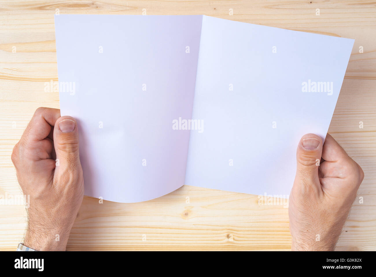 Man holding blank brochure as mock up copy space for graphic design or text placement Stock Photo