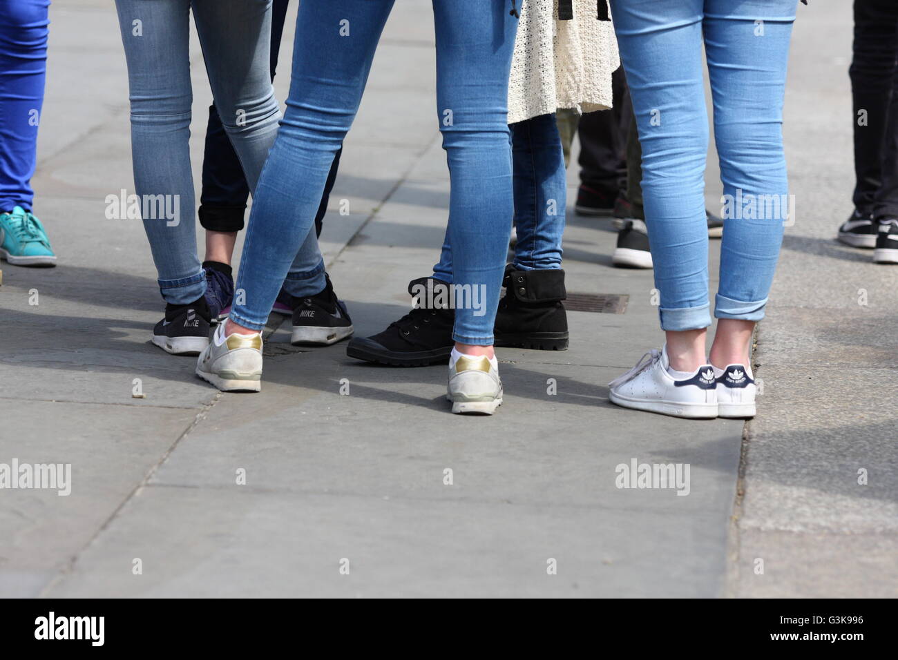 The legs of a crowd of youths standing in Trafalgar Square, London, England Stock Photo