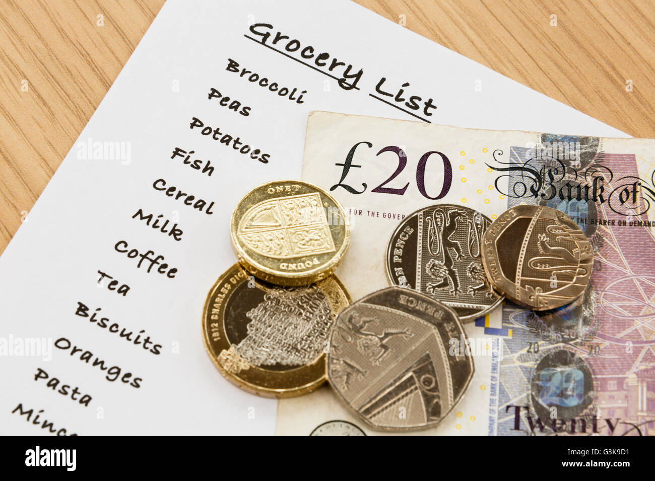 Shopping list for groceries with sterling money cash from above. England, UK, Britain Stock Photo