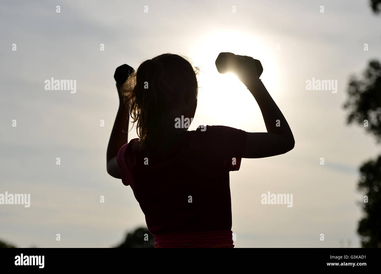 Silhouette of girl exercising outside Stock Photo