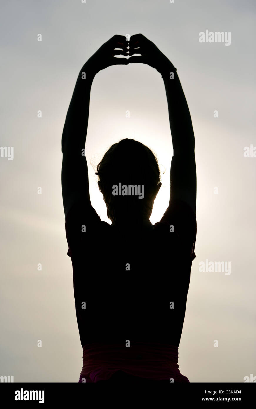 Silhouette of girl exercising outside Stock Photo
