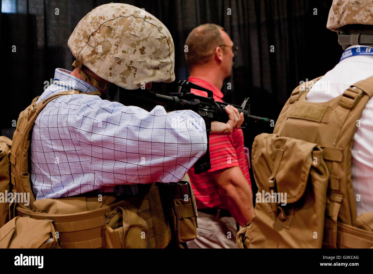 Man target shooting simulator using an M16 at a military expo - USA Stock Photo