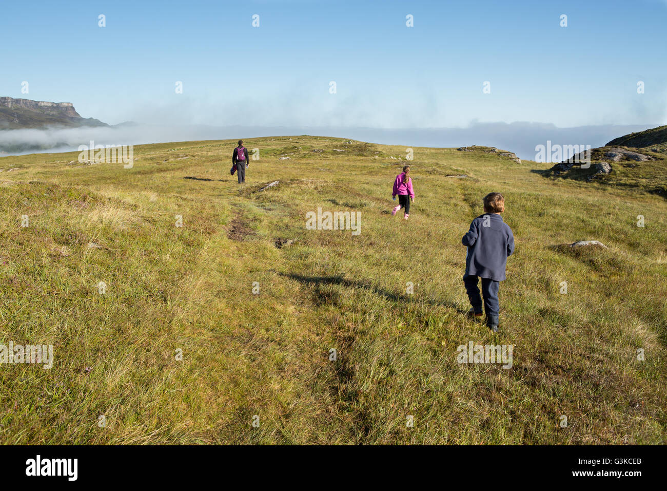 Family walking towards the sea near Garrafad, northeast coast of Isle of Skye, Inner Hebrides, Scotland, UK Stock Photo