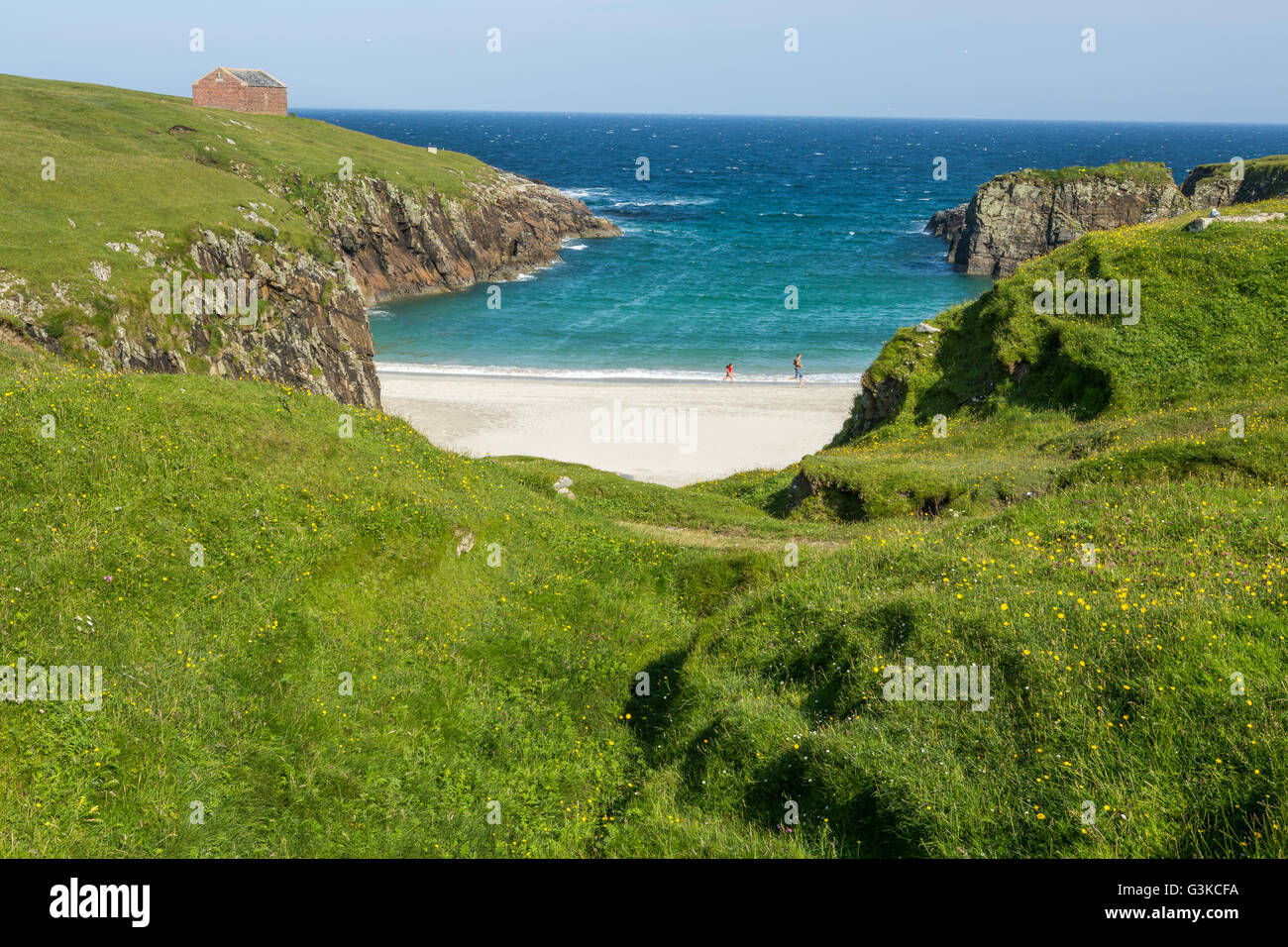 View of beautiful bay and people running along thel beach on a sunny day, Isle of Lewis, Outer Hebrides, Scotland, UK Stock Photo