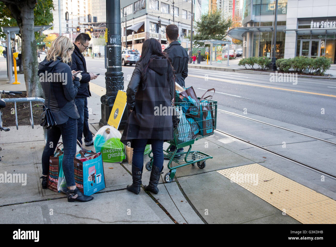 Whole Foods grocery shoppers waiting for  the bus or streetcar in Seattle, Washington Stock Photo