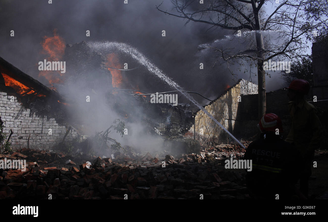 Lahore, Abkhazia. 21st Apr, 2016. Pakistani fire fighters extinguishing from burning factory building while heavy smoke fire flame rises from burning goods after fire broken out incident at motorcycle factory. At least three workers were injured during huge fire erupts in the foam factory in Lahore. © Rana Sajid Hussain/Pacific Press/Alamy Live News Stock Photo