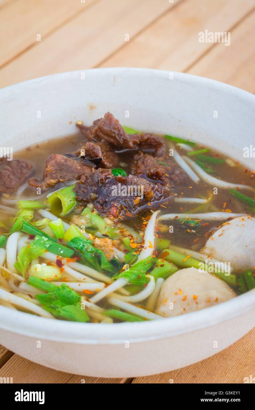 Noodle soup with beef in thai or chinese style on table background