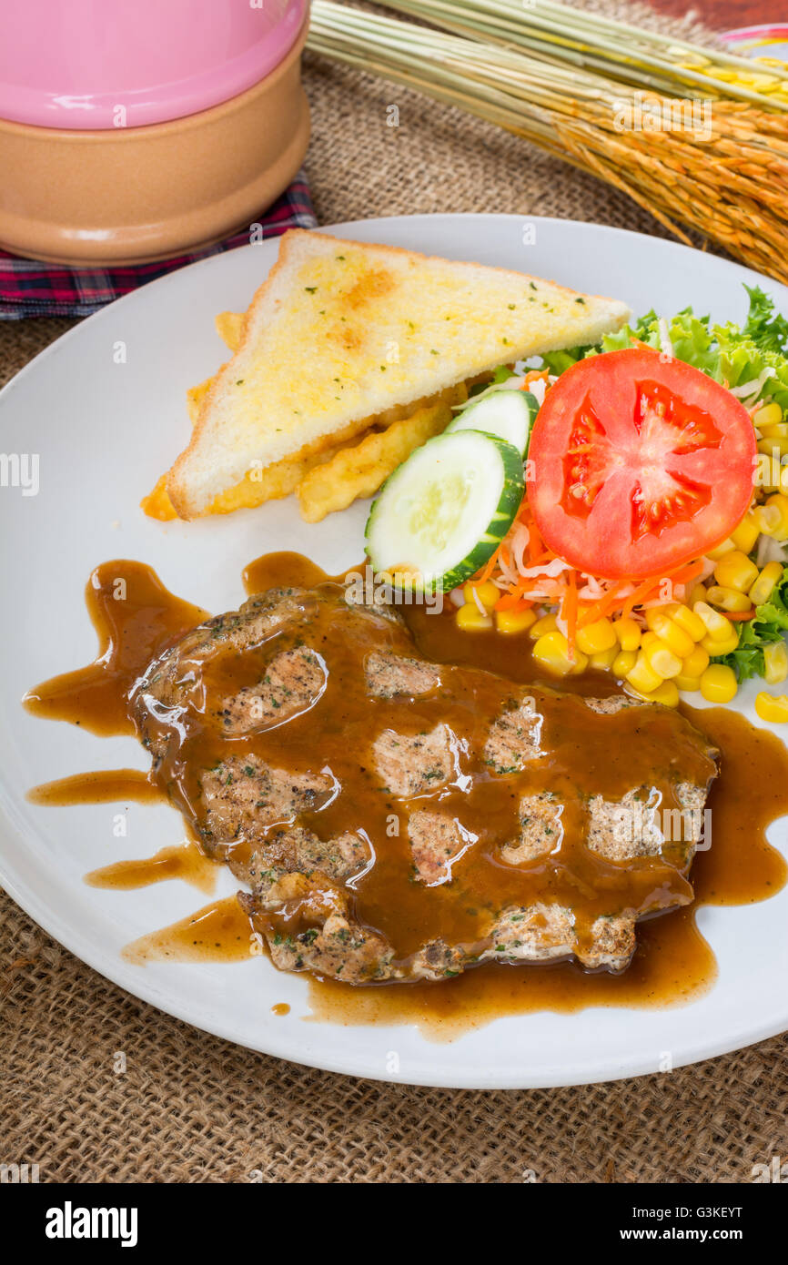 Beef steak with black pepper sauce , salad and French fries on sack