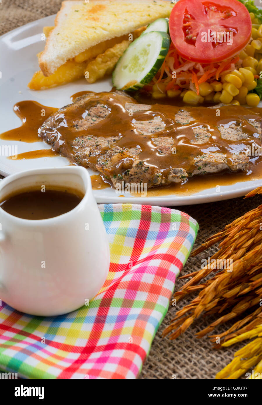 Beef steak with black pepper sauce , salad and French fries on sack